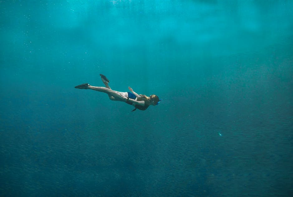 A person diving underwater with a spear gun in hand, ready to hunt.