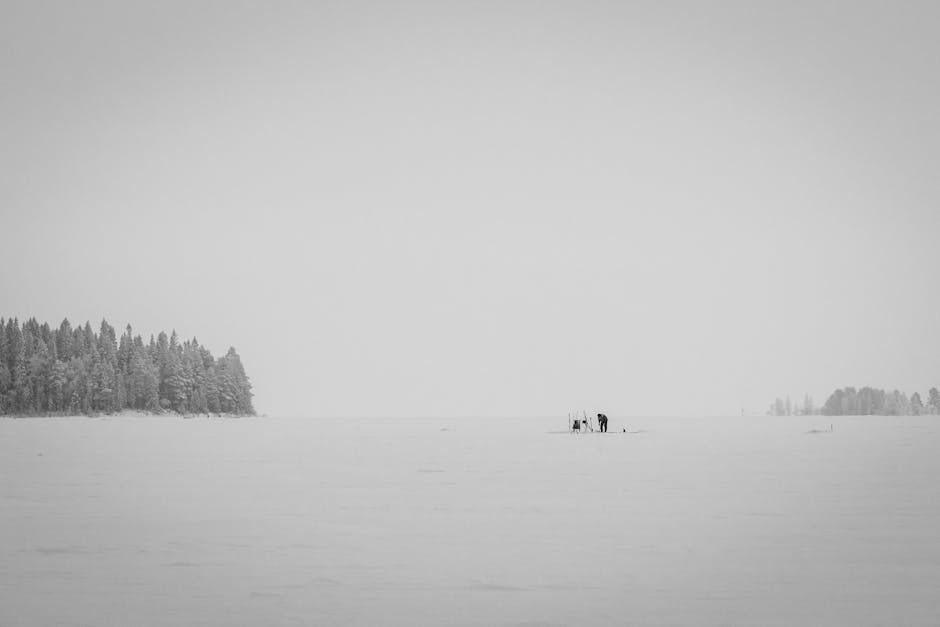 Imagem de um homem pescando em um lago no inverno