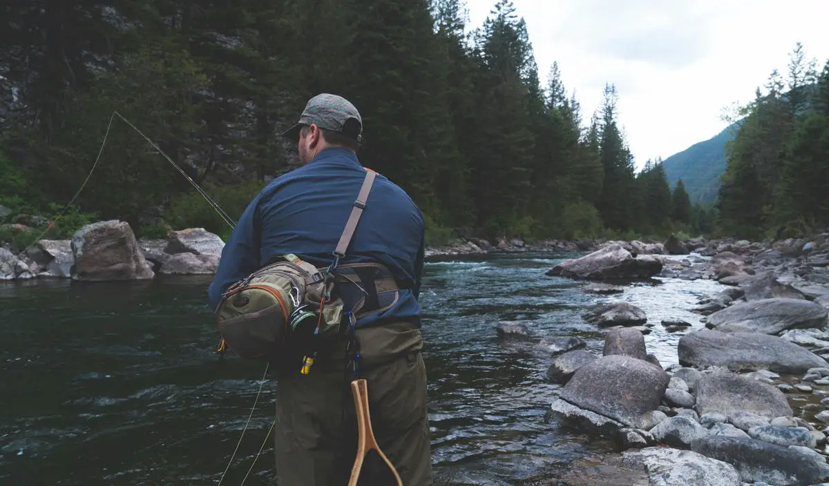 Foto de um pescador em um lago de inverno, seguindo as dicas para uma pesca bem sucedida