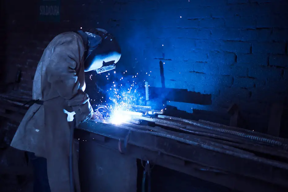 Trabalhador industrial usando equipamentos de proteção individual completos enquanto opera uma máquina, incluindo capacete, óculos, protetor auricular e luvas.